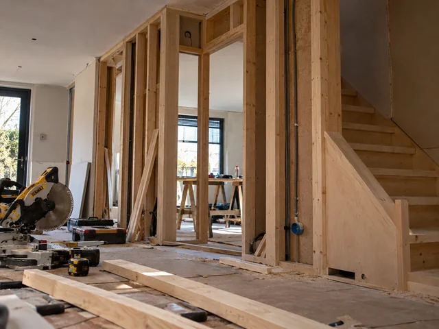 Ruimte in aanbouw met houten regelwerk en een nieuwe houten trap
